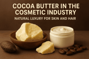 Chunks of natural cocoa butter in a wooden bowl beside a jar of cream and cocoa beans on a brown background, representing its use in cosmetics for skin and hair.